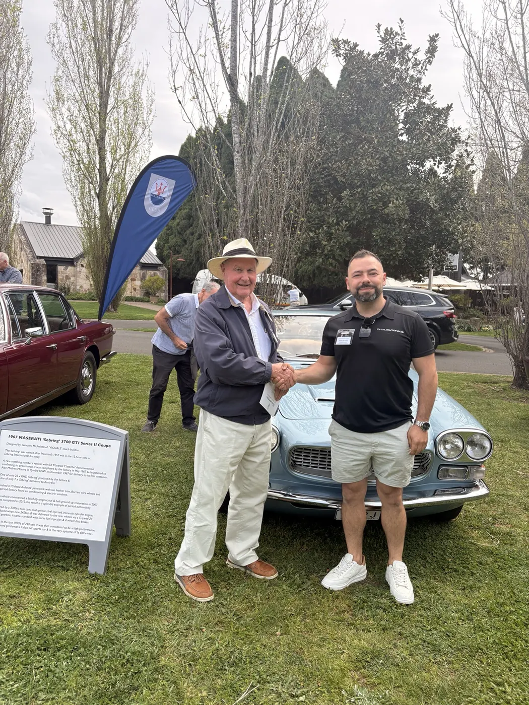 Detail AutoHaus receiving recognition beside a concours-winning classic Maserati