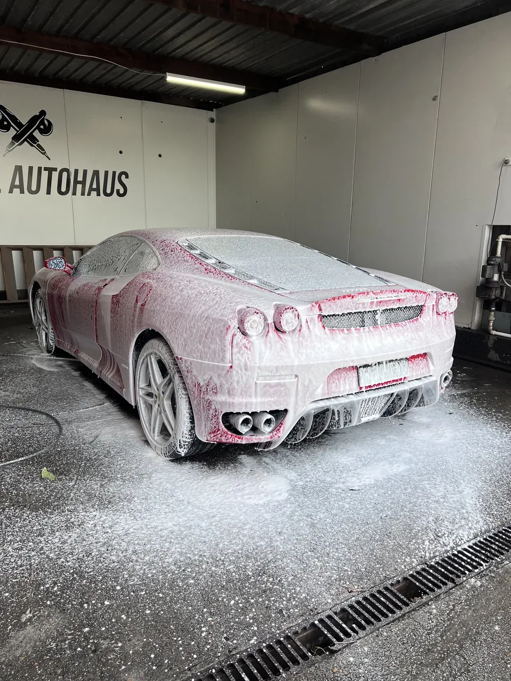 Ferrari covered in snow foam in the wash bay
