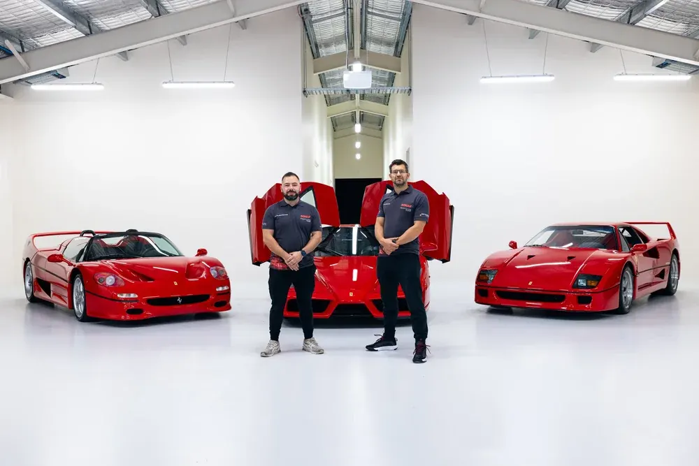 The Detail AutoHaus team in a white studio with three red Ferraris