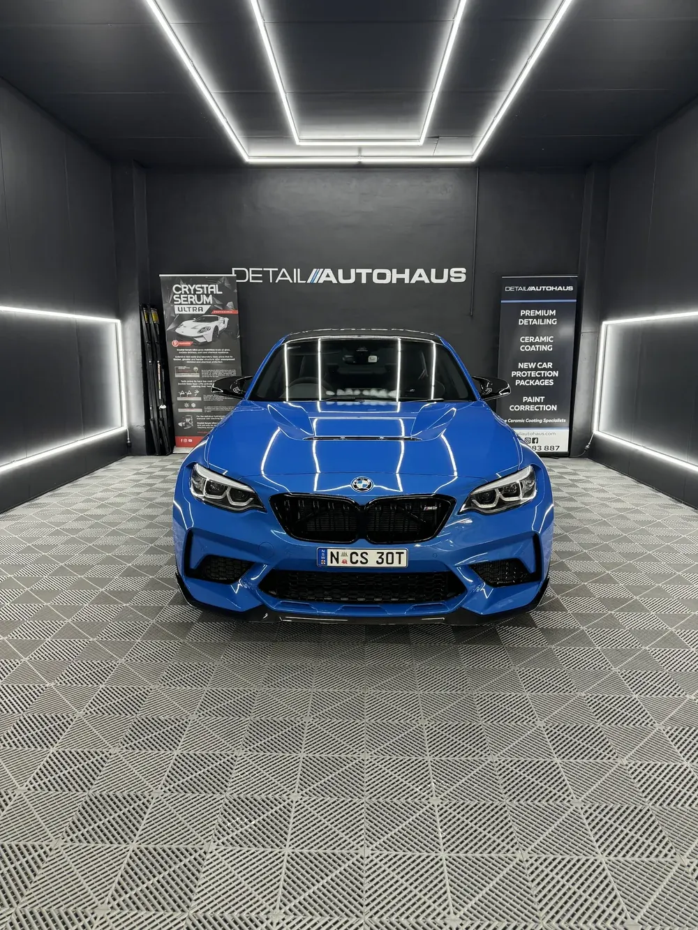Blue BMW M2 under the light tunnel in the Detail AutoHaus studio